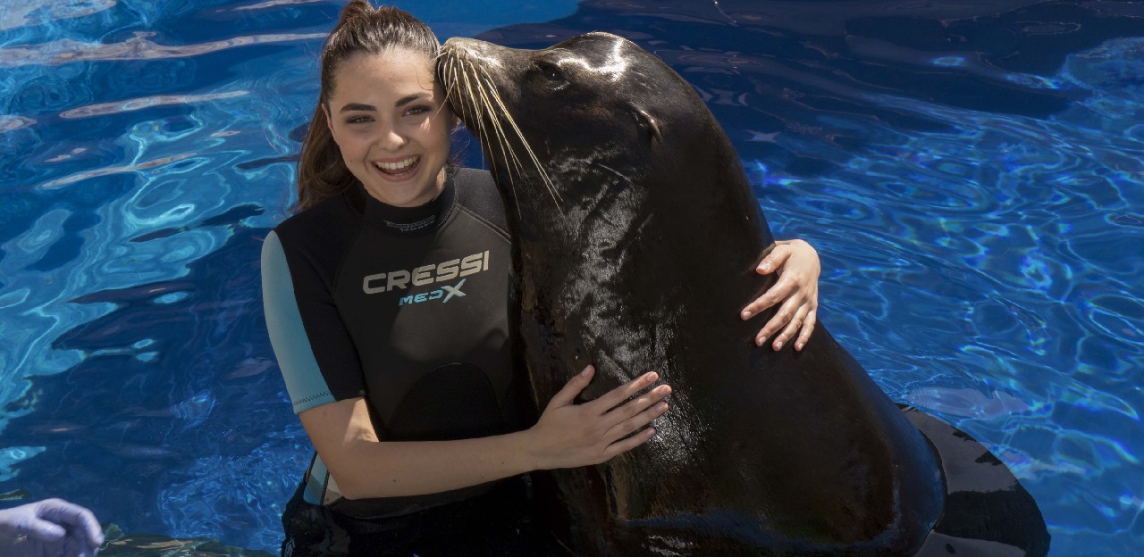 Girl posing with a sea lion
